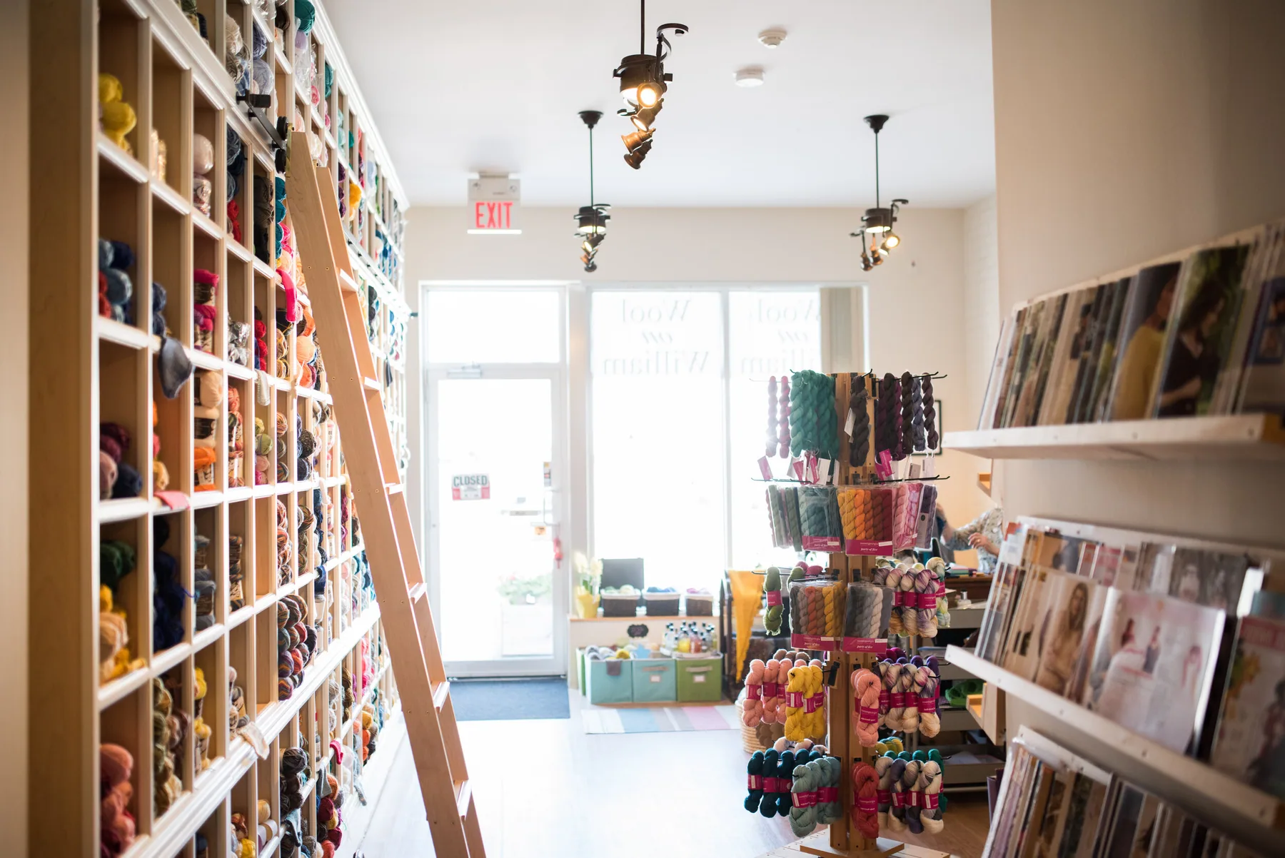 Colourful yarn and pattern shelves inside Wool On William